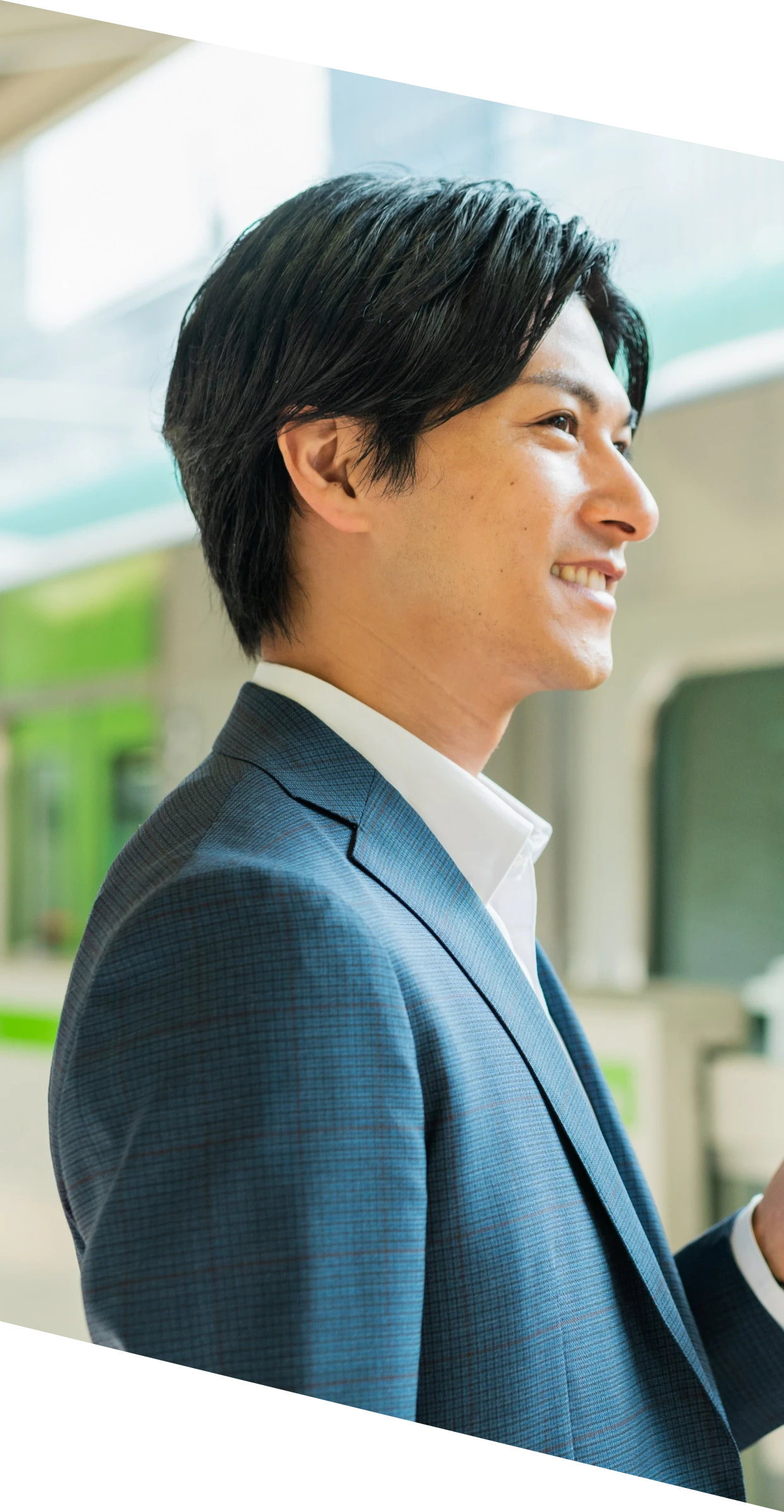 スマートフォンを持って歩くスーツ姿の男性