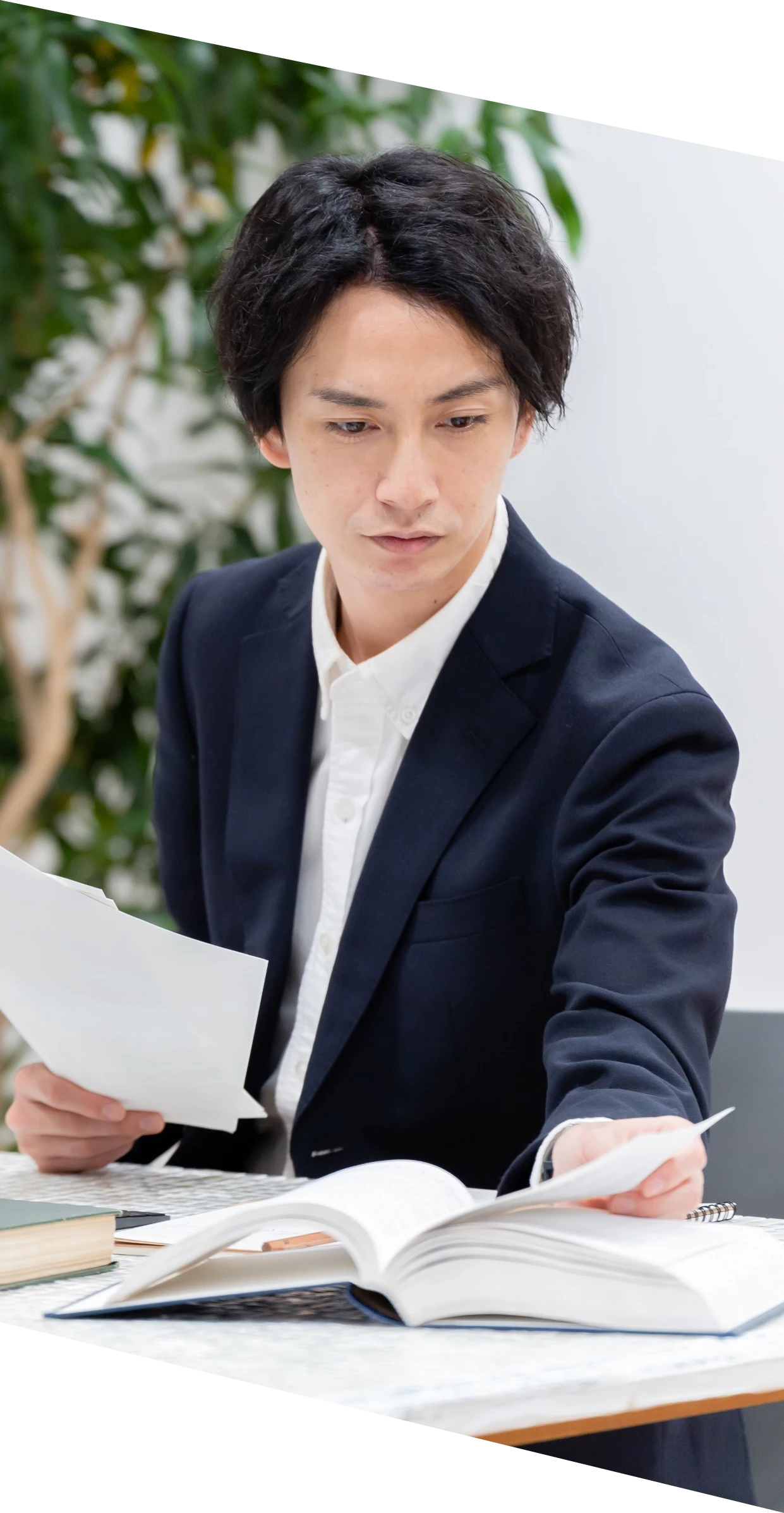 デスクで書類を確認するスーツ姿の男性